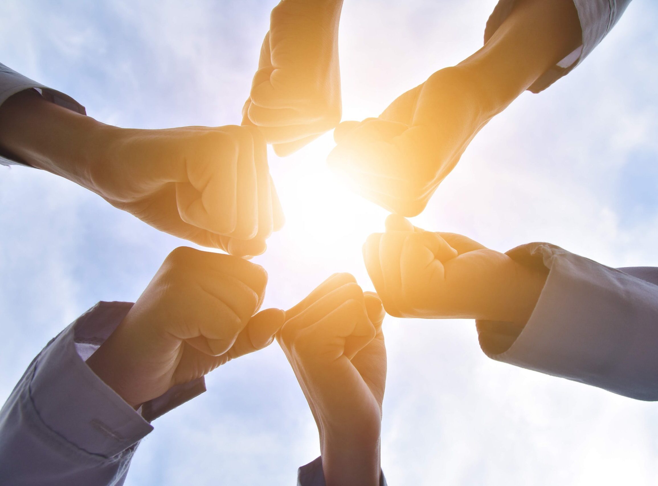 Teamwork with people joining fists in a circle